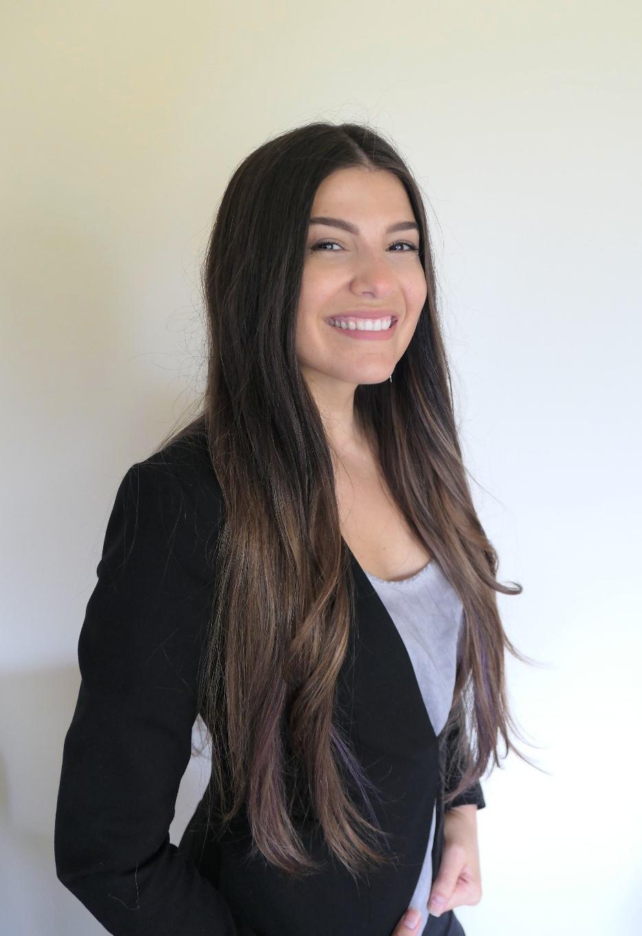 A person smiling at the camera Description automatically generated