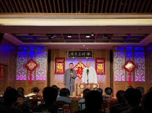 A person on a stage with a microphone Description automatically generated